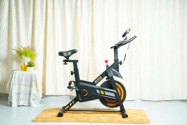 A stationary bike on a rug in front of a curtain