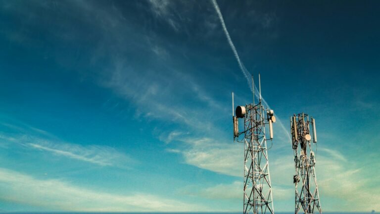 Black metal cell tower under a blue sky