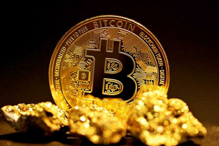 A bitcoin on a pile of gold nuggets